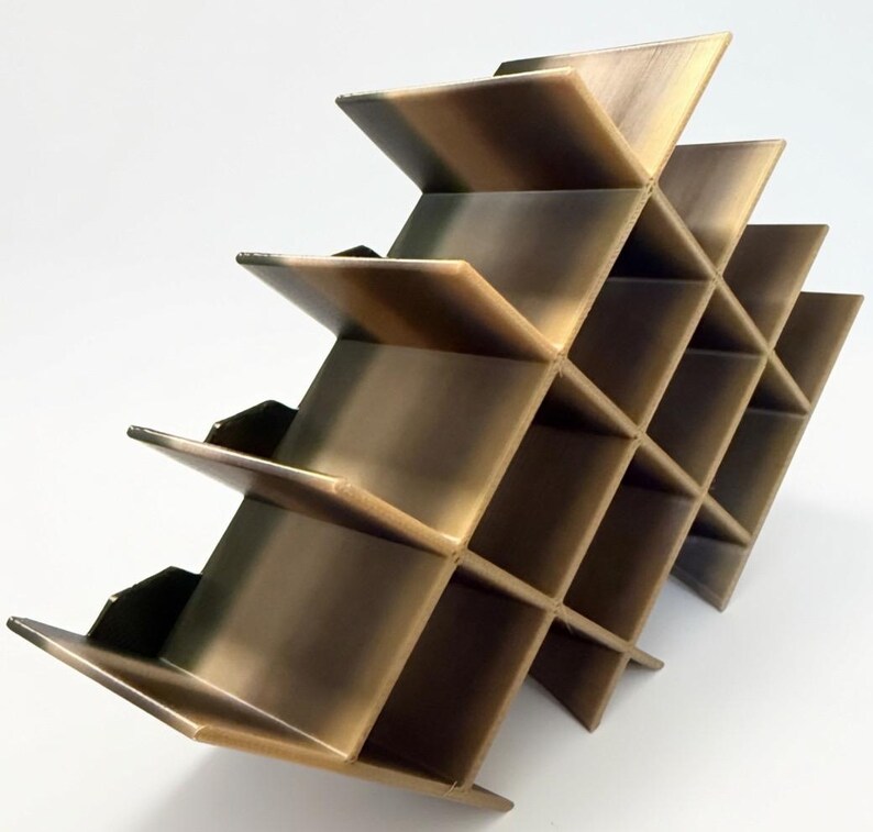Puede incluir: Un botellero de metal color bronce con un dise&ntilde;o de rejilla geom&eacute;trica y m&uacute;ltiples compartimentos cuadrados. La estructura est&aacute; compuesta por paneles que se cruzan creando una serie de espacios abiertos para botellas.