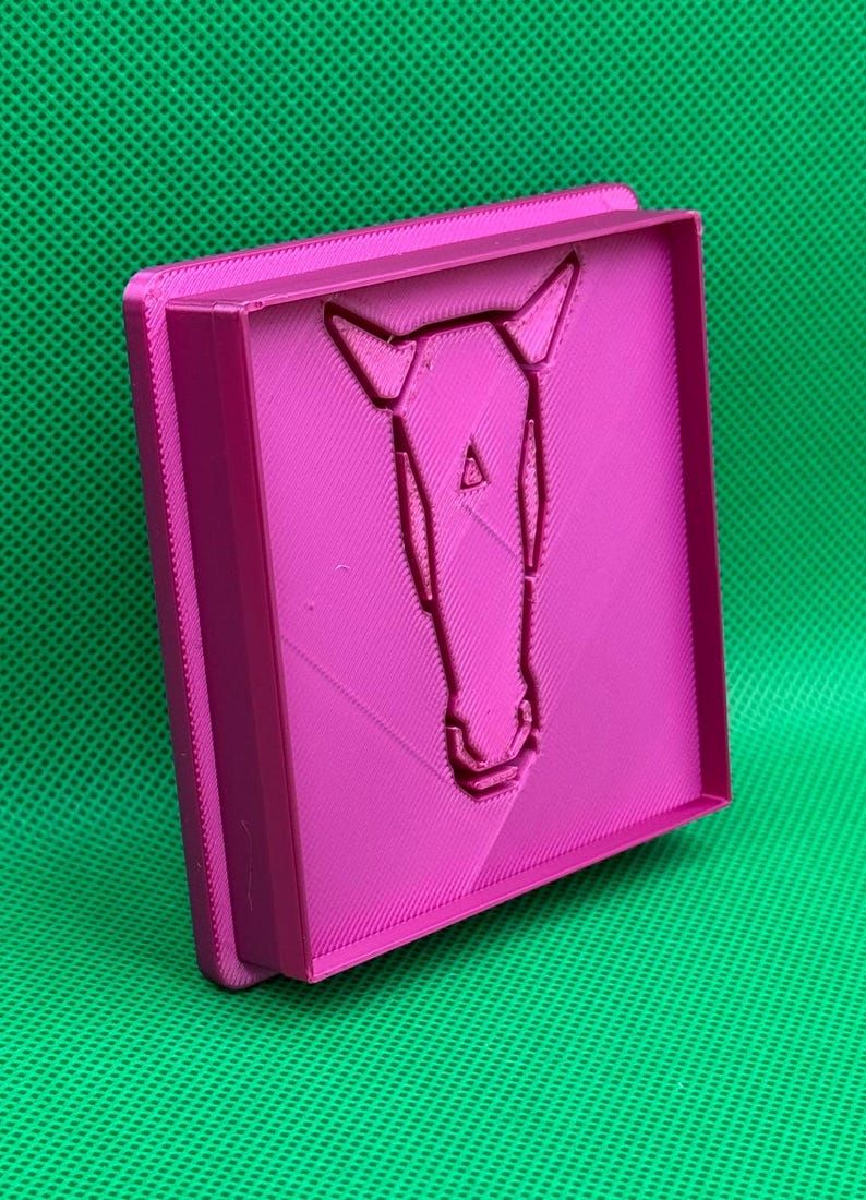 K&ouml;nnte beinhalten: Eine rosa 3D-gedruckte Form mit einem geometrischen Pferdekopf-Design.