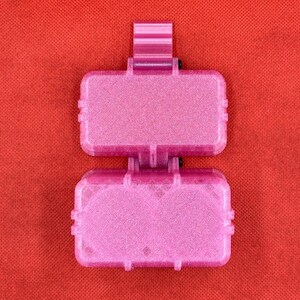 May include: Two pink plastic containers with a sparkly finish. The containers are stacked on top of each other. The top container has a small handle.