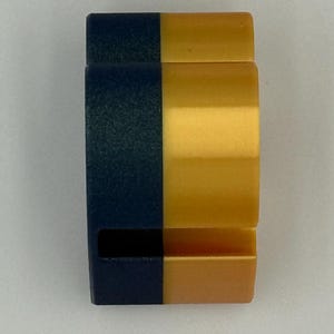 May include: A two-tone, rectangular object with a navy blue and gold color scheme. The object is divided vertically, with the left side navy blue and the right side gold. The object has a curved shape.