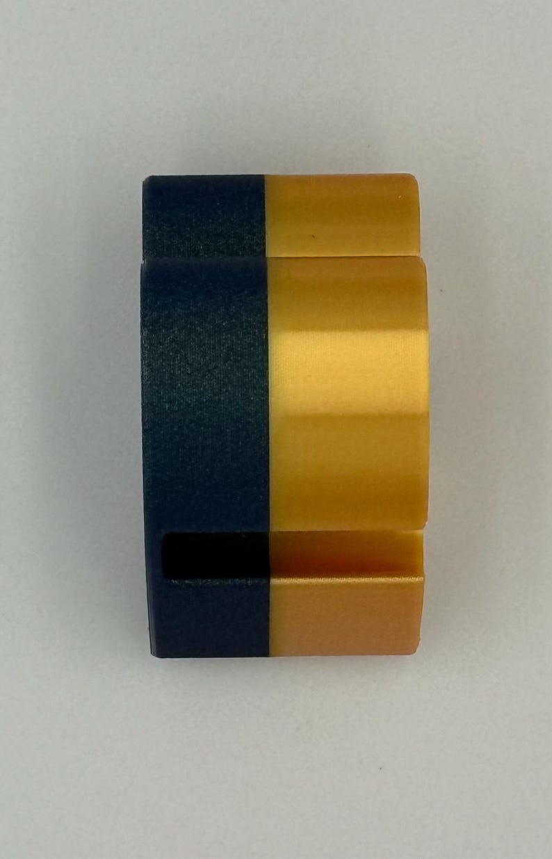 May include: A two-tone, rectangular object with a navy blue and gold color scheme. The object is divided vertically, with the left side navy blue and the right side gold. The object has a curved shape.