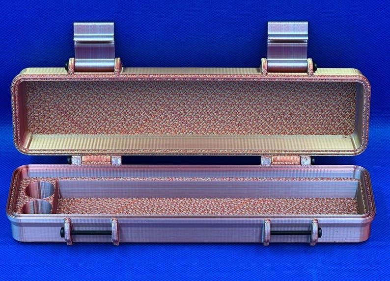 May include: An open, rectangular, pink-hued plastic case with a textured interior. The case has two latches on the top and a handle on the bottom.