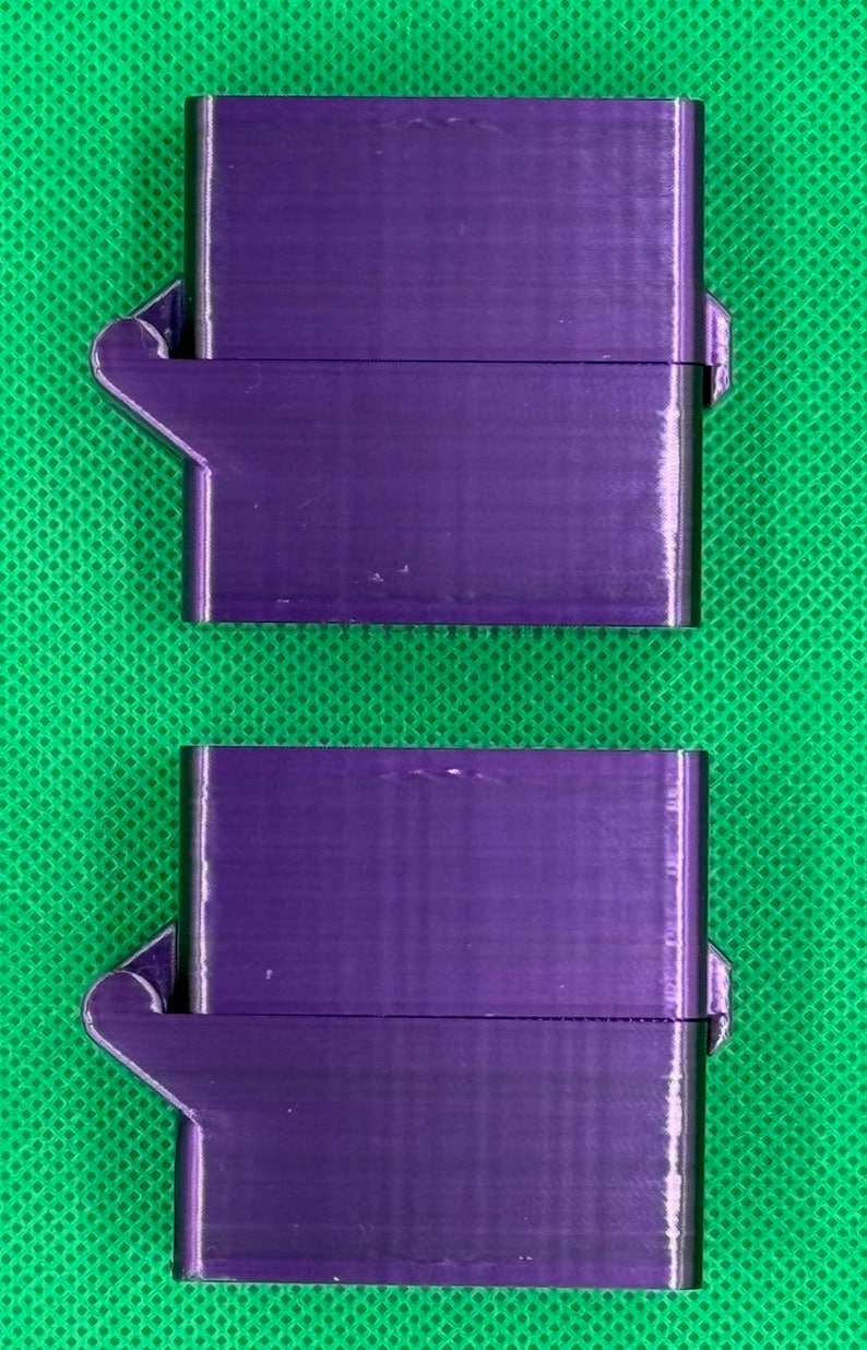May include: Two purple plastic snap-on boxes with a hinged lid. The boxes are stacked on top of each other.