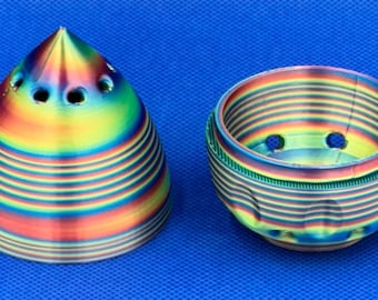 May include: Two 3D printed objects, a cone and a bowl, with a rainbow iridescent finish. Both objects have multiple holes in the top.