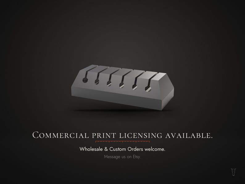 Op de afbeelding: Een grijs, rechthoekig kabelorganizerblok met vijf gelijkmatig verdeelde verticale sleuven met cirkelvormige openingen aan de basis. De tekst luidt: COMMERCIAL PRINT LICENSING AVAILABLE. Wholesale & Custom Orders welcome. Message us on Etsy.