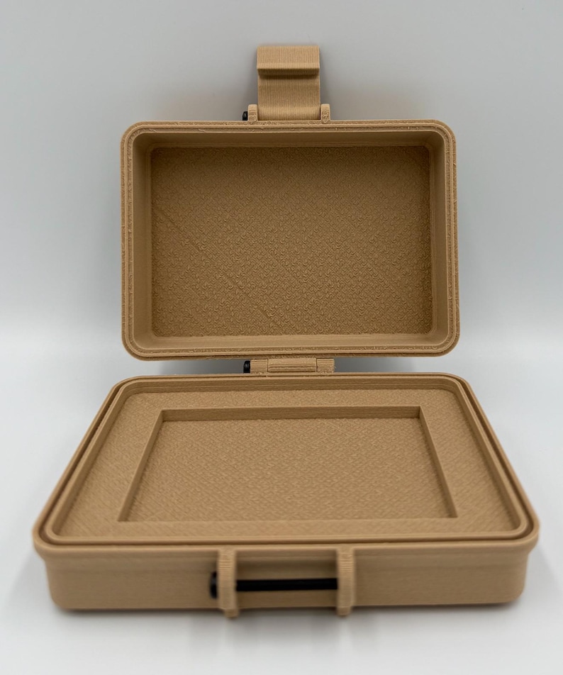 Puede incluir: Peque&ntilde;o malet&iacute;n beige abierto, con interior texturizado. De forma rectangular, tiene tapa con bisagras y cierre negro. El malet&iacute;n est&aacute; hecho de un material s&oacute;lido y parece estar vac&iacute;o.