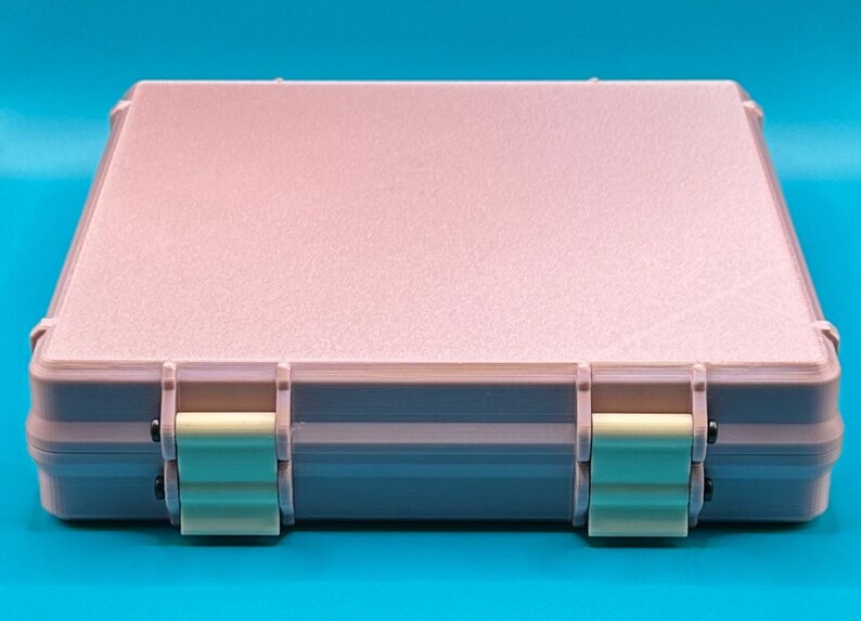 May include: A light pink plastic storage case with two latches on the front. The case has a textured surface and is closed.