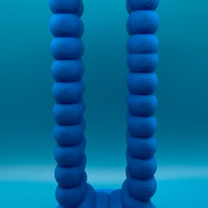 May include: A blue 3D printed sculpture shaped like an archway. The archway is made up of a series of connected spheres.