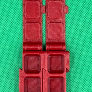 Puede incluir: Una caja de almacenamiento de pl&aacute;stico roja con una tapa con bisagras. La caja tiene ocho compartimentos, cada uno con forma cuadrada.