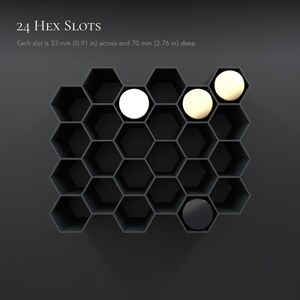 May include: A black honeycomb-style organizer with 24 hex slots. Each slot measures 23 mm (0.91 in) across and 70 mm (2.76 in) deep. The unit features four circular inserts in white, cream, and black colors placed within the hexagonal openings.