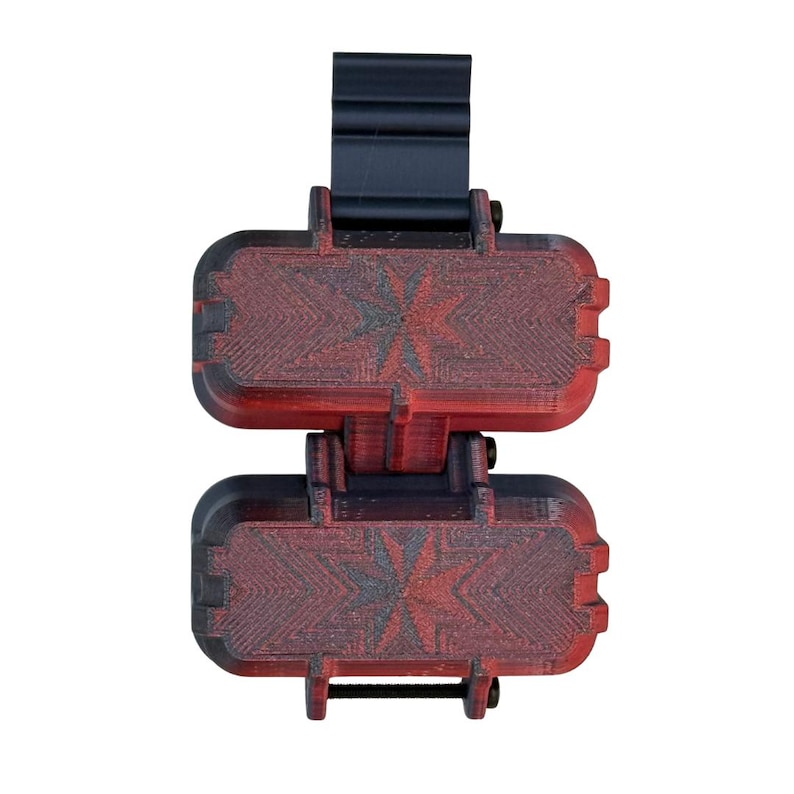 Puede incluir: Un dispositivo rectangular de dos secciones con acabado degradado en negro y rojo y un patr&oacute;n texturizado en forma de estrella en el frente. La unidad incluye un soporte de montaje vertical negro en la parte superior y tornillos met&aacute;licos.