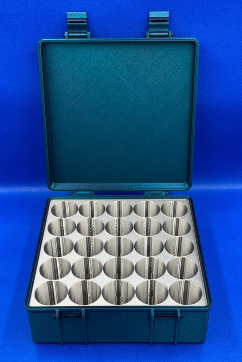 May include: A teal green plastic storage case with a hinged lid. The case has 24 round compartments for storing small items.