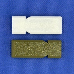May include: Two rectangular plastic components with a textured surface and a notched side. One component is solid white, and the other is olive green. Both items feature a flat, elongated shape with a distinct indentation on one side.