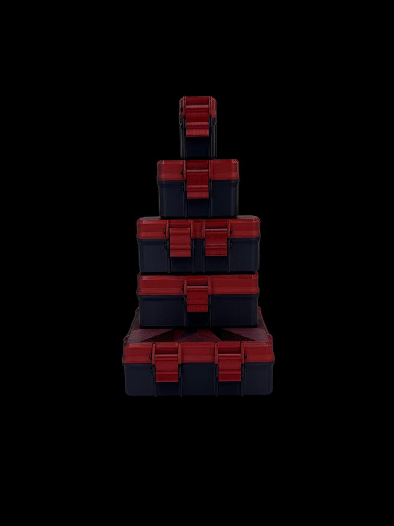 May include: A stack of five rectangular storage cases arranged from smallest at the top to largest at the bottom. Each case is dark blue with a red lid and features two red locking latches on the front for secure closure.