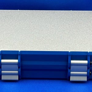 K&ouml;nnte beinhalten: Eine blaue Plastik-Aufbewahrungsbox mit einem silbernen Deckel. Die Box hat zwei Verschl&uuml;sse an jeder Seite und eine strukturierte Oberfl&auml;che.