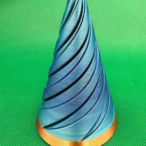 May include: A blue and copper 3D printed Christmas tree ornament with a spiral design.