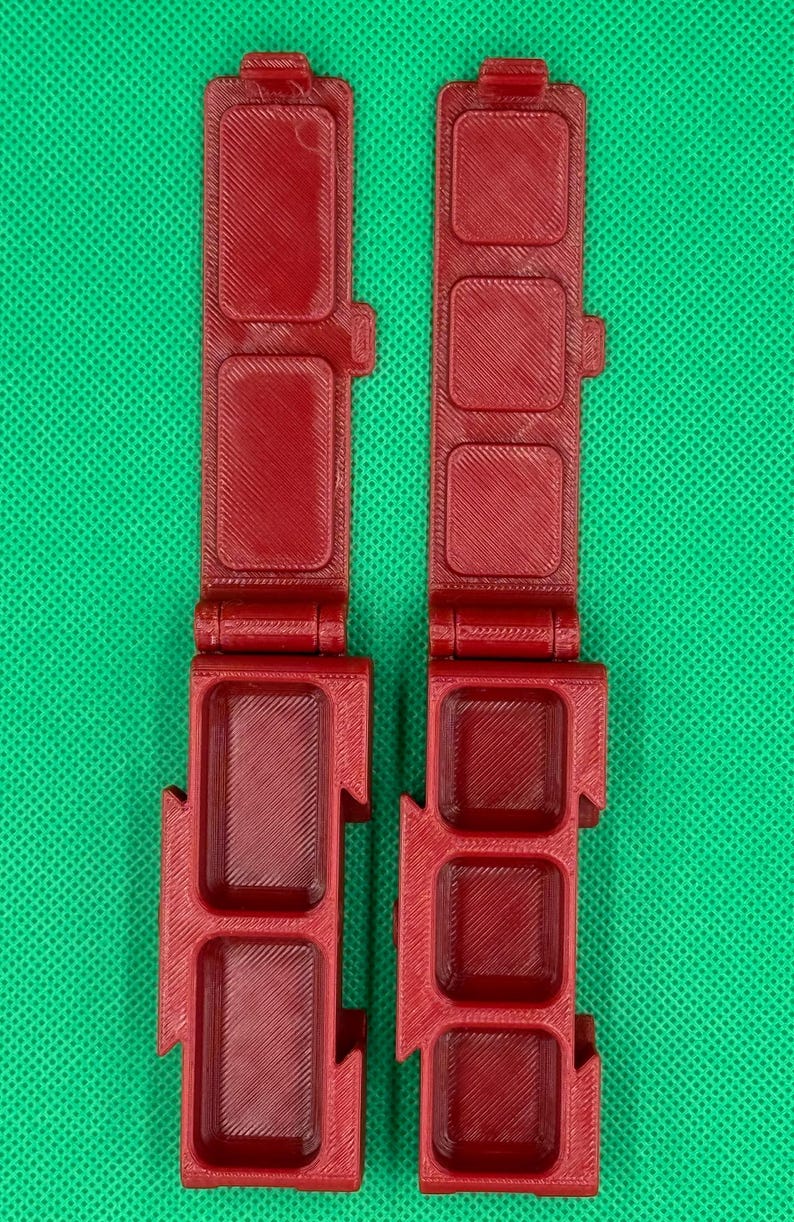 Puede incluir: Dos cajas de pl&aacute;stico rojo con bisagras y m&uacute;ltiples compartimentos. Cada caja tiene tres filas de compartimentos.