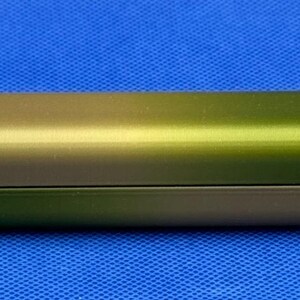 May include: A cylindrical, metallic container with a gradient finish, transitioning from a light gold to a dark green color.