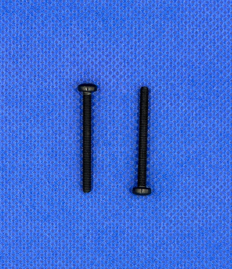 May include: Two black screws with a flat head and a Phillips head on a blue background.