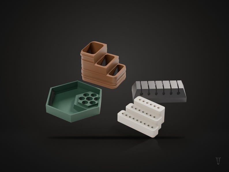 May include: A collection of desk organizers including a brown tiered tray, a green hexagonal tray with a circular insert, a dark gray rectangular block with vertical slots, and a white three-tiered stand with small circular holes.
