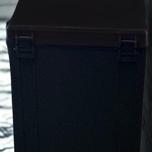 May include: A black rectangular box with a hinged lid. The box has a textured surface and a darker trim around the lid. The box appears to be made of a durable material, suitable for storage or transport.