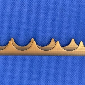K&ouml;nnte beinhalten: Ein goldfarbener Metallst&auml;nder mit acht Schlitzen zum Aufbewahren von kleinen Gegenst&auml;nden. Der St&auml;nder hat an jedem Ende zwei vertikale St&uuml;tzen.