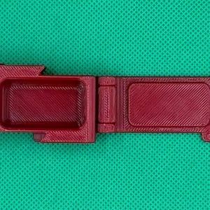 Puede incluir: Una caja de almacenamiento de pl&aacute;stico burdeos con tres compartimentos. La caja est&aacute; abierta y los compartimentos est&aacute;n vac&iacute;os.