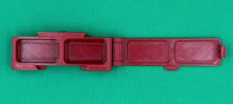 Puede incluir: Una caja de almacenamiento de pl&aacute;stico burdeos con tres compartimentos. La caja est&aacute; abierta y los compartimentos est&aacute;n vac&iacute;os.