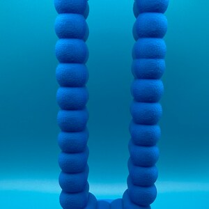 May include: A blue 3D printed archway sculpture made of a series of connected spheres. The archway is standing on a blue base.