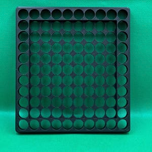 May include: Black plastic storage tray with a grid of circular holes. The tray is designed to hold small items, such as coins, beads, or buttons.