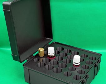 May include: A black rectangular storage case with a hinged lid, featuring a molded interior insert with twenty-five circular slots. Three small glass bottles with white and gold caps are placed in the slots of the organizer case.