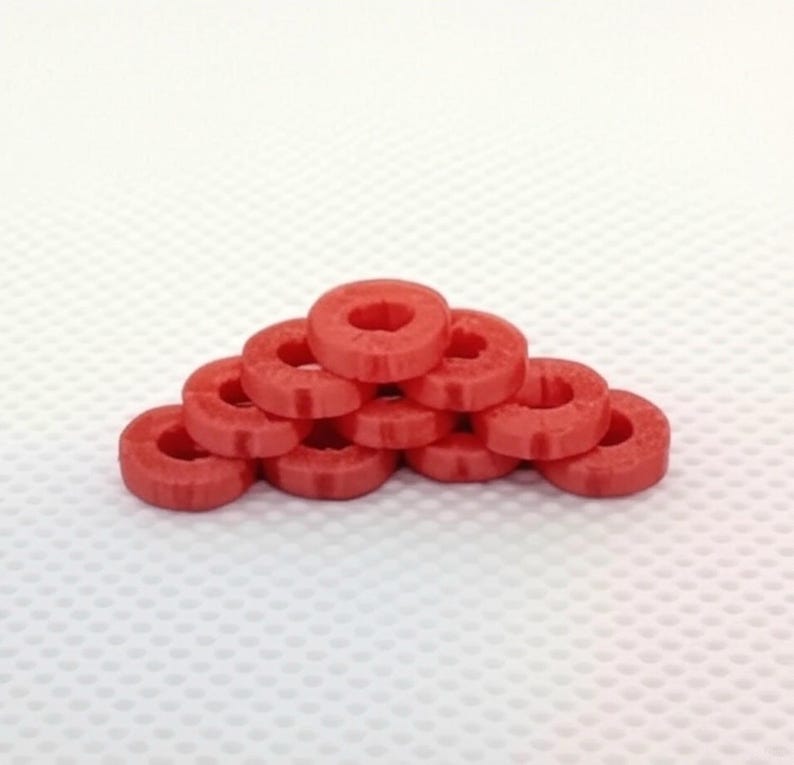 May include: A stack of ten red plastic rings, arranged in a pyramid shape.