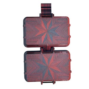 Puede incluir: Un estuche de almacenamiento rectangular de dos compartimentos con dise&ntilde;o de bisagra. Las superficies exteriores presentan un degradado de negro intenso y rojo vibrante, con un patr&oacute;n de estrella geom&eacute;trico grabado en el pl&aacute;stico.