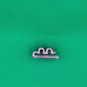 May include: A small, light pink plastic clip with a wavy design. The clip is designed to hold items together.