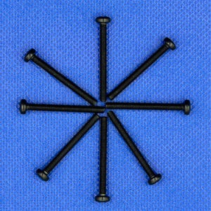 May include: Six black screws arranged in a star pattern on a blue surface.