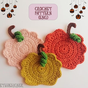 May include: Three crocheted pumpkin-shaped coasters in shades of pink, orange, and yellow. Each coaster has a brown stem and a green leaf. The image includes text that says "CROCHET PATTERN (ENG)" and Halloween-themed decorations.