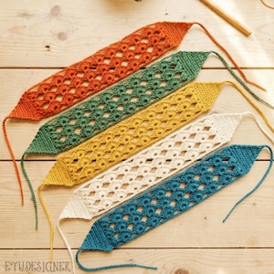 May include: Five colorful, crocheted headbands in orange, green, yellow, cream, and teal. Each headband features an openwork design and a long, thin tie. The headbands are arranged diagonally on a light wooden surface.