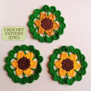 May include: Three crocheted sunflower coasters in green, yellow, and brown. The coasters are made with a simple stitch pattern and have a delicate, feminine look.