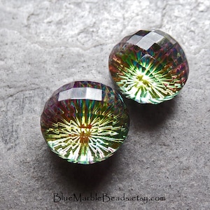 May include: Two iridescent green and purple faceted glass cabochons with a starburst pattern. The cabochons are approximately 1 inch in diameter.