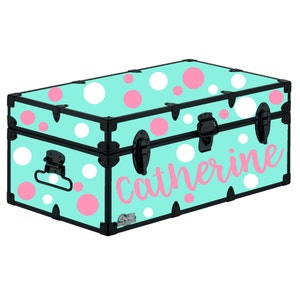 May include: A turquoise blue storage trunk with a polka dot pattern in white and pink. The name "Catherine" is written in pink on the front of the trunk.