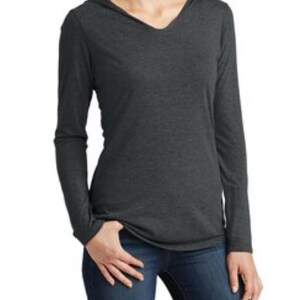 May include: A long-sleeved hooded shirt in a dark heather grey color. The shirt has a v-neck and a relaxed fit.