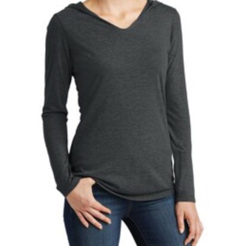 May include: A long-sleeved hooded shirt in a dark heather grey color. The shirt has a v-neck and a relaxed fit.