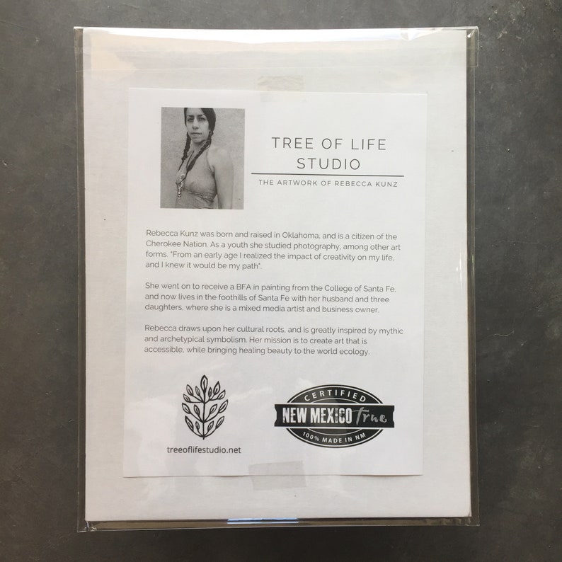 May include: A black and white photo of a woman with long dark hair wearing a red tank top and a necklace. The photo is on a white background with text that reads "Tree of Life Studio, The Artwork of Rebecca Kunz". The text below the photo describes the artist and her work. The text includes the words "Cherokee Nation", "Santa Fe", "mixed media artist", and "cultural roots". The bottom of the image includes a logo that reads "Certified New Mexico True 100% Made in NM" and the website address "treeoflifestudio.net".