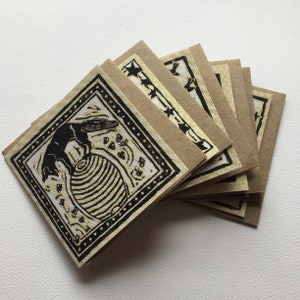 May include: A set of eight blank cards with a black and white illustration of a fox jumping over a striped ball. The cards are made of brown paper and have a black border.