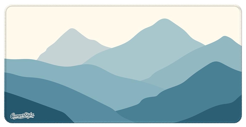 May include: A rectangular mousepad with a mountain range design in shades of blue. The image shows layers of mountains in different tones, set against a light beige sky. The words "CamperStylz" are in the lower left corner.
