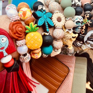 Artículo nuevo - Muy popular - Llavero de pulsera con cuentas y portadocumentos. Cartera con bloqueo RFID para mayor seguridad. Inventario reabastecido.