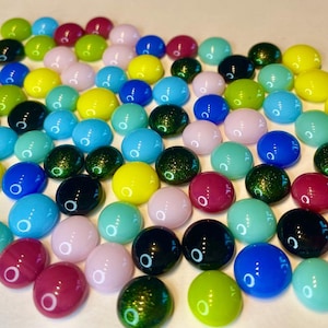 May include: A collection of colorful glass marbles in various shades of blue, green, yellow, pink, and red. The marbles have a smooth, rounded shape and a glossy finish. These decorative marbles are suitable for crafts, games, or home decor.
