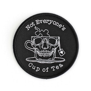 May include: Black and white embroidered patch with a skull in a teacup and the text "Not Everyone's Cup of Tea".