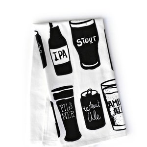 May include: A white kitchen towel with black illustrations of different types of beer, including IPA, Stout, Pilsner, Wheat Ale, and Amber Ale.
