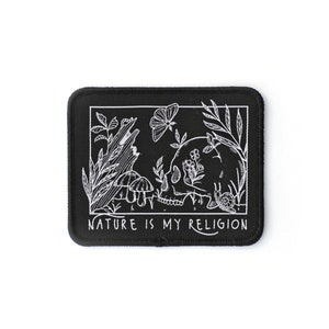 May include: Black rectangular patch with a white illustration of a skull, mushrooms, plants, a butterfly, and a snail. The text "NATURE IS MY RELIGION" is at the bottom. The patch has a black border and is on a white background.